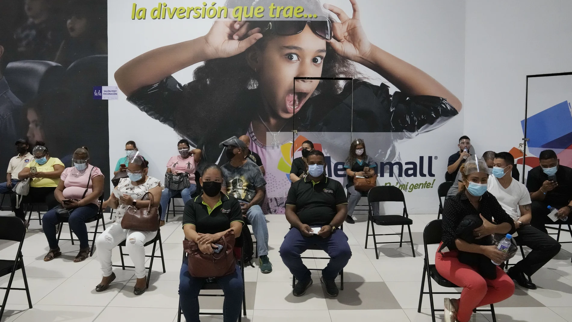 Residents sit in observation after getting shots of the AstraZeneca vaccine for COVID-19 at Mega Mall on the outskirts of Panama City, Wednesday, June 9, 2021. (AP Photo/Arnulfo Franco)