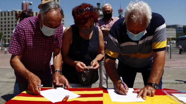 Varios ciudadanos firman la petición contra la concesión de indultos a los condenados por el "procés" en una mesa instalada por el Partido Popular en Barcelona, este domingo