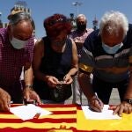 Varios ciudadanos firman la petición contra la concesión de indultos a los condenados por el "procés" en una mesa instalada por el Partido Popular en Barcelona, este domingo