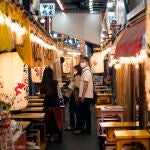 Tokyo (Japan), 17/06/2021.- Passersby walk through a narrow alley between restaurants in Tokyo, Japan, 17 June 2021, the day the government decided to lift in nine prefectures including Tokyo the COVID-19 state of emergency, which is due to end on 20 June 2021. The government also decided to keep restrictions to avoid a rebound of infections before the Tokyo Olympics. (Japón, Tokio) EFE/EPA/FRANCK ROBICHON