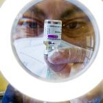 Un sanitario prepara las dosis de la vacuna contra la COVID-19, AstraZeneca,en un centro de vacunaciones en Nápoles, en Italia