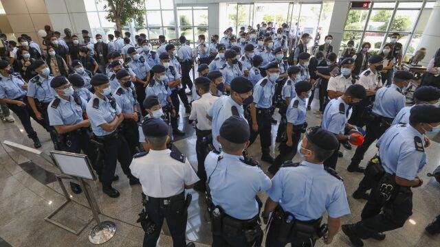 Police gather in the lobby of the Apple Daily headquarters in Hong Kong, Thursday, June 17, 2021. Hong Kong police on Thursday morning arrested the chief editor and four other senior executives of Apple Daily under the national security law on suspicion of collusion with a foreign country to endanger national security, according to local media reports. (Apple Daily via AP)