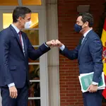El presidente del Gobierno, Pedro Sánchez (i), saluda al presidente de la Junta de Andalucía, Juanma Moreno, a las puertas del Palacio de la Moncloa, donde este jueves celebraron su primer encuentro oficial desde que ambos ostentan los cargos actuales.