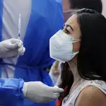 Una mujer reciba una vacuna contra la covid-19