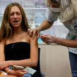 Una adolescente en Israel reacciona al pinchazo de una vacuna