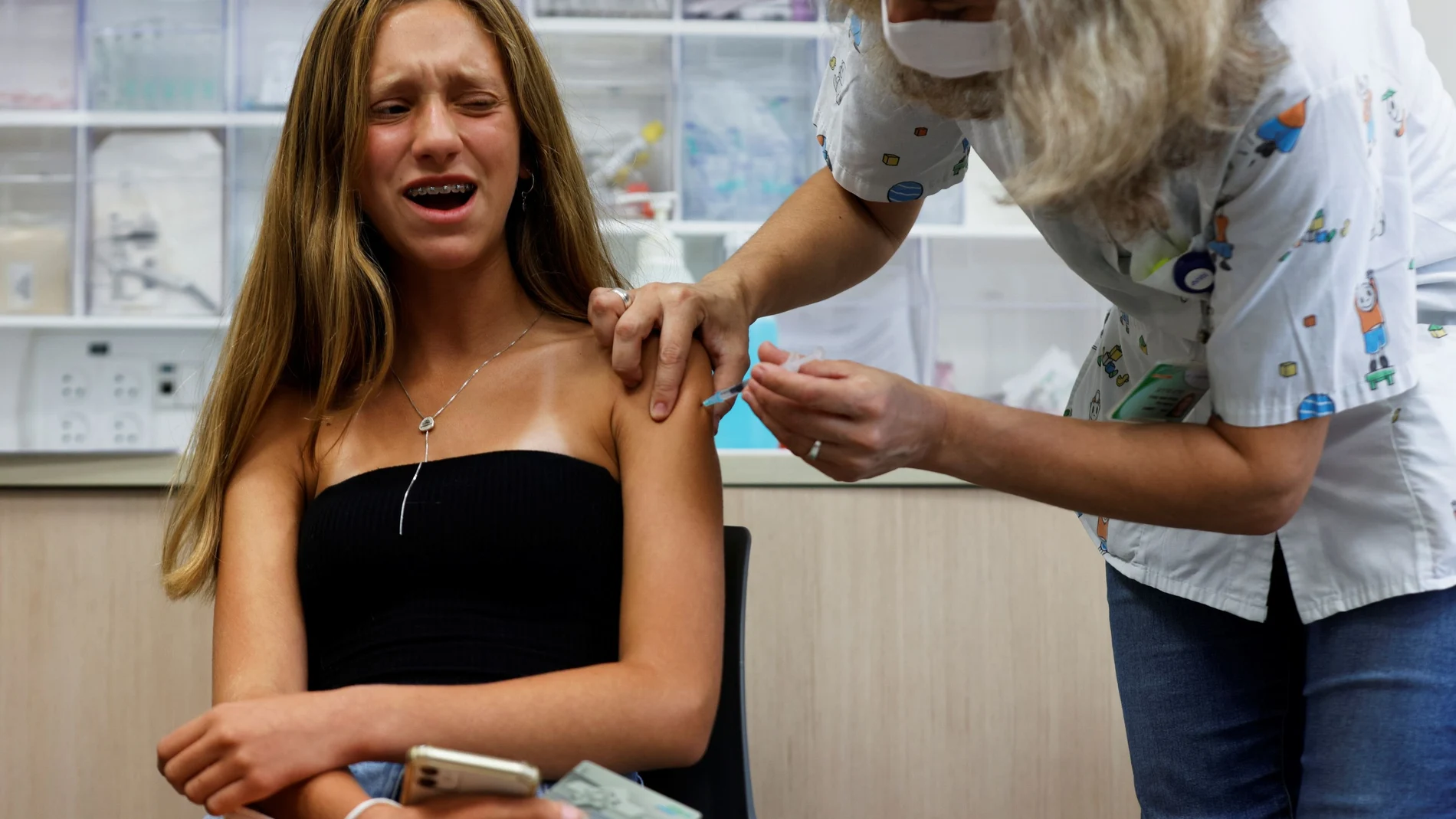 Una adolescente en Israel reacciona al pinchazo de una vacuna