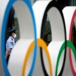 Un guardia de seguridad detrás del monumento de los anillos olímpicos, en las inmediaciones del estadio olímpico de Tokio. Los Juegos Olímpicos, que comenzarán el 23 de julio de 2021, fueron pospuestos un año a causa de la pandemia de la covid-19.