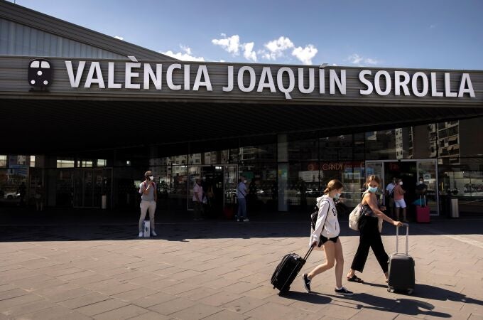 Dos personas transportan sus maletas a la salida de la estación de tren Joaquín Sorolla de València