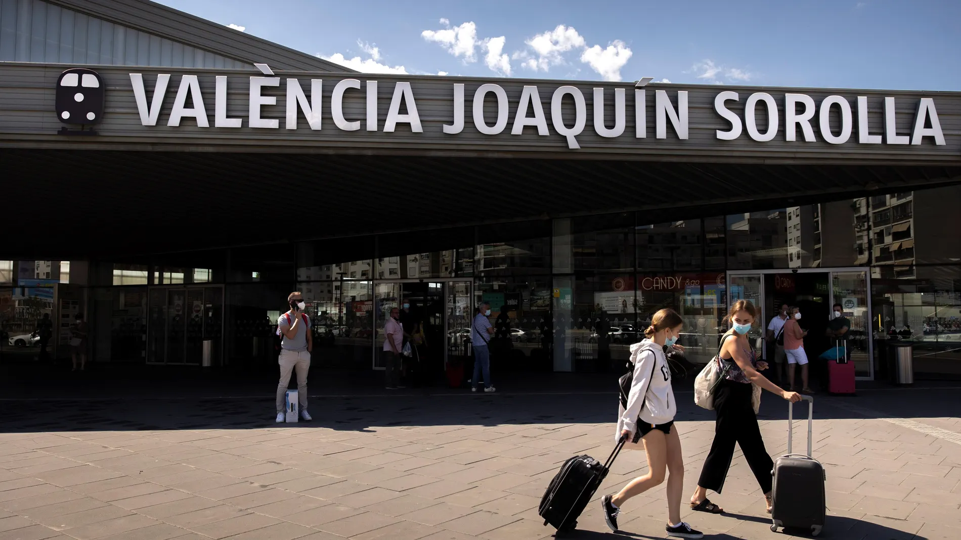 Dos personas transportan sus maletas a la salida de la estación de tren Joaquín Sorolla de València