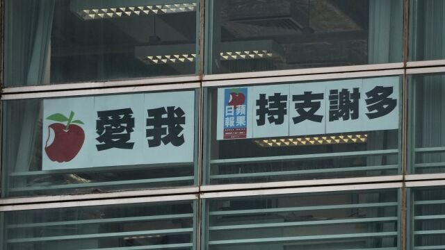Chinese characters reading "I love Apple Daily, thanks for supporting" hang in a window at the Apple Daily headquarters in Hong Kong, Wednesday, June 23, 2021. Hong Kongâ€™s pro-democracy Apple Daily newspaper will close by this weekend, its parent company said Wednesday, following last weekâ€™s arrest of five editors and executives and the freezing of $2.3 million in assets under the cityâ€™s national security law. (AP Photo/Kin Cheung)