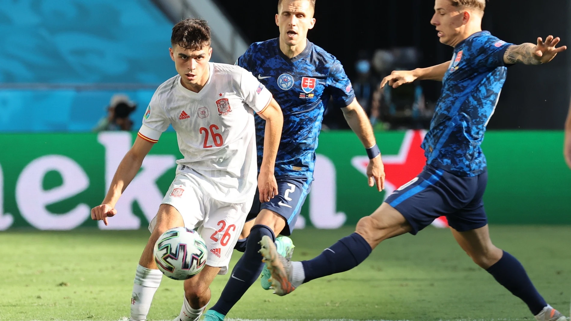 El centrocampista de la selección española Pedri González controla el balón ante los jugadores de Eslovaquia, el defensa Peter Pekarik y el centrocampista Tomás Suslov, durante el encuentro perteneciente al grupo E de la Eurocopa 2020