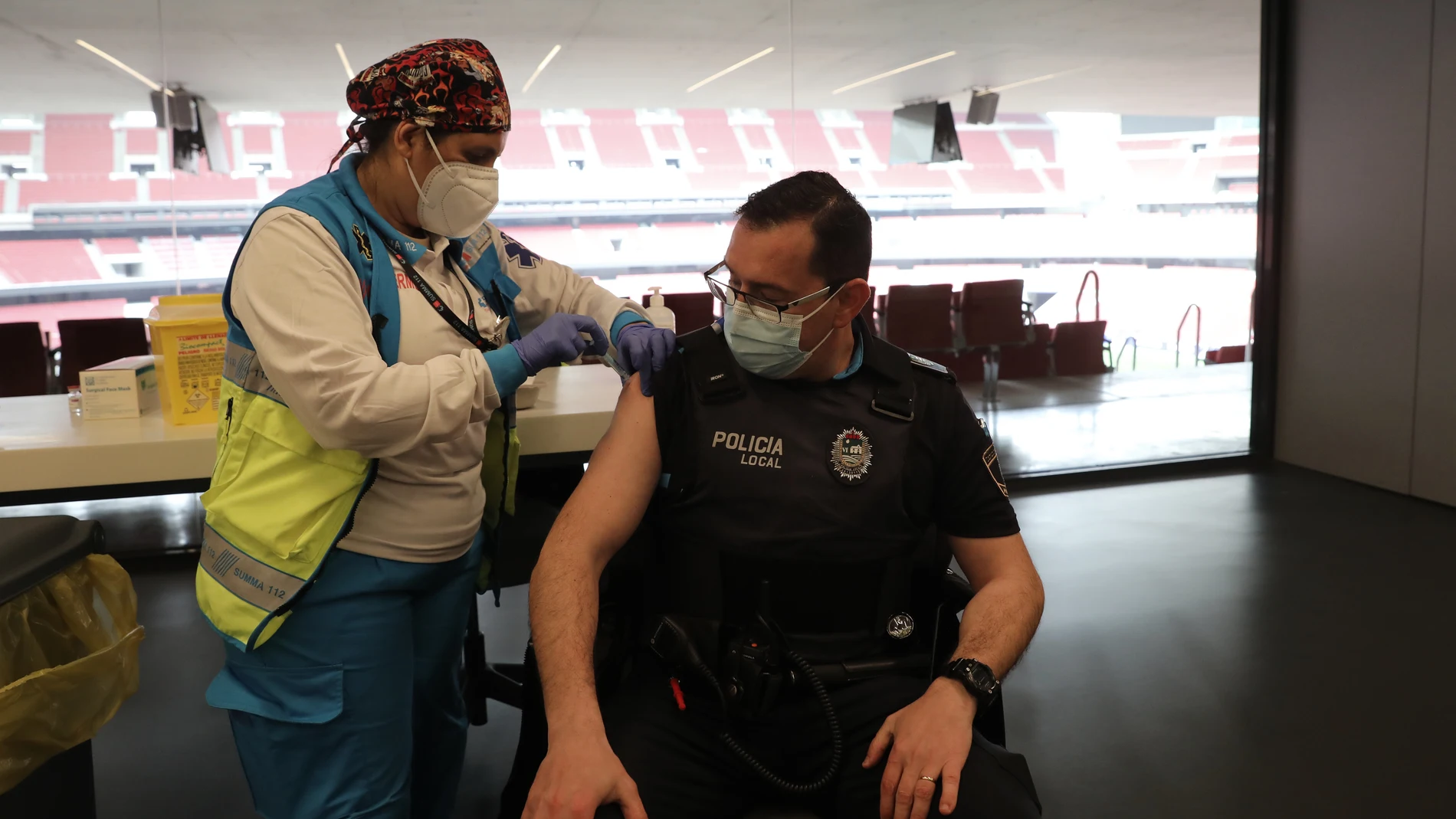 Un agente de la Policía Local recibe una dosis de la vacuna de AstraZeneca en el Wanda