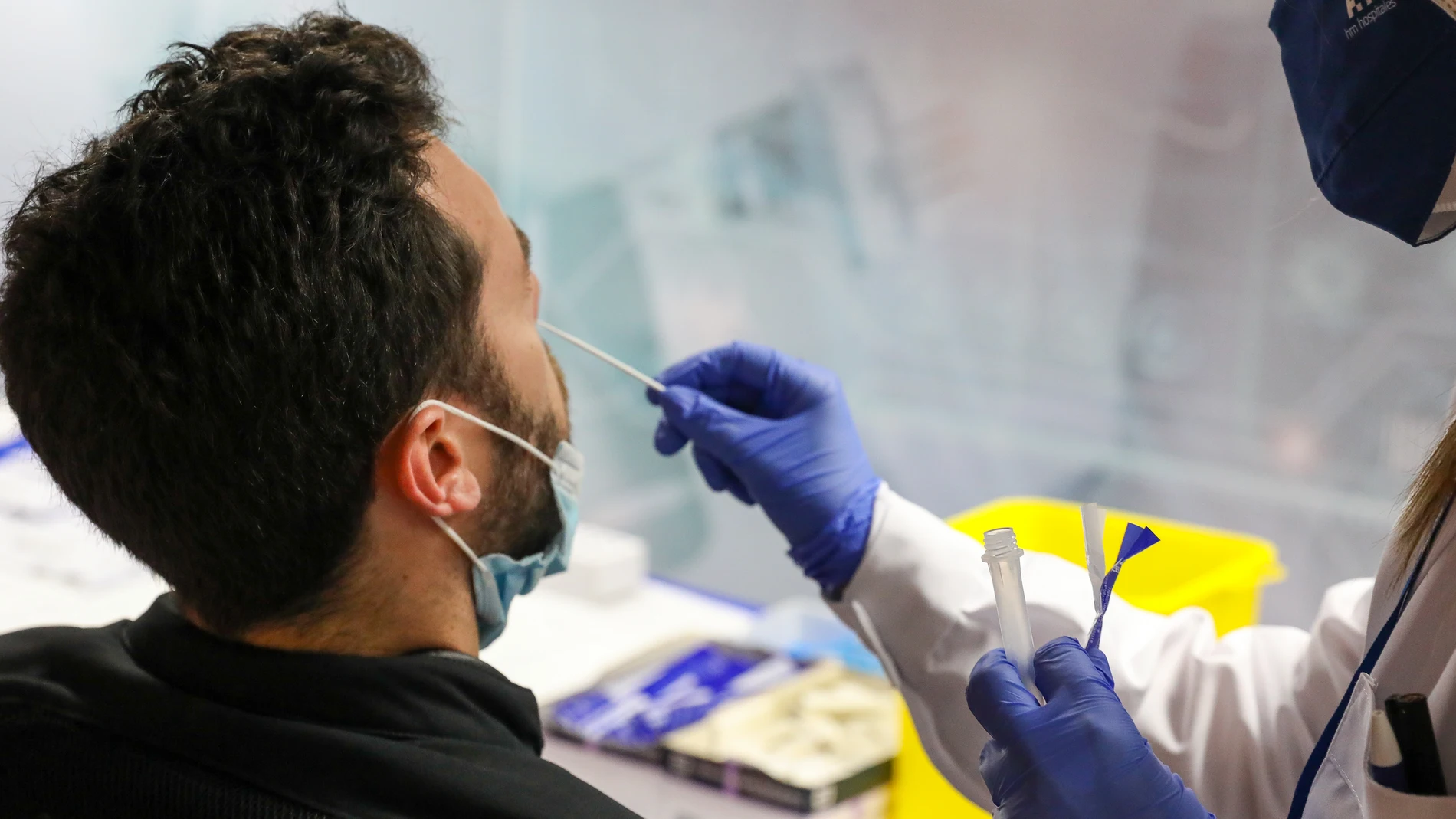 Un sanitario realiza un test de antígenos a un hombre en el intercambiador de Plaza de Castilla