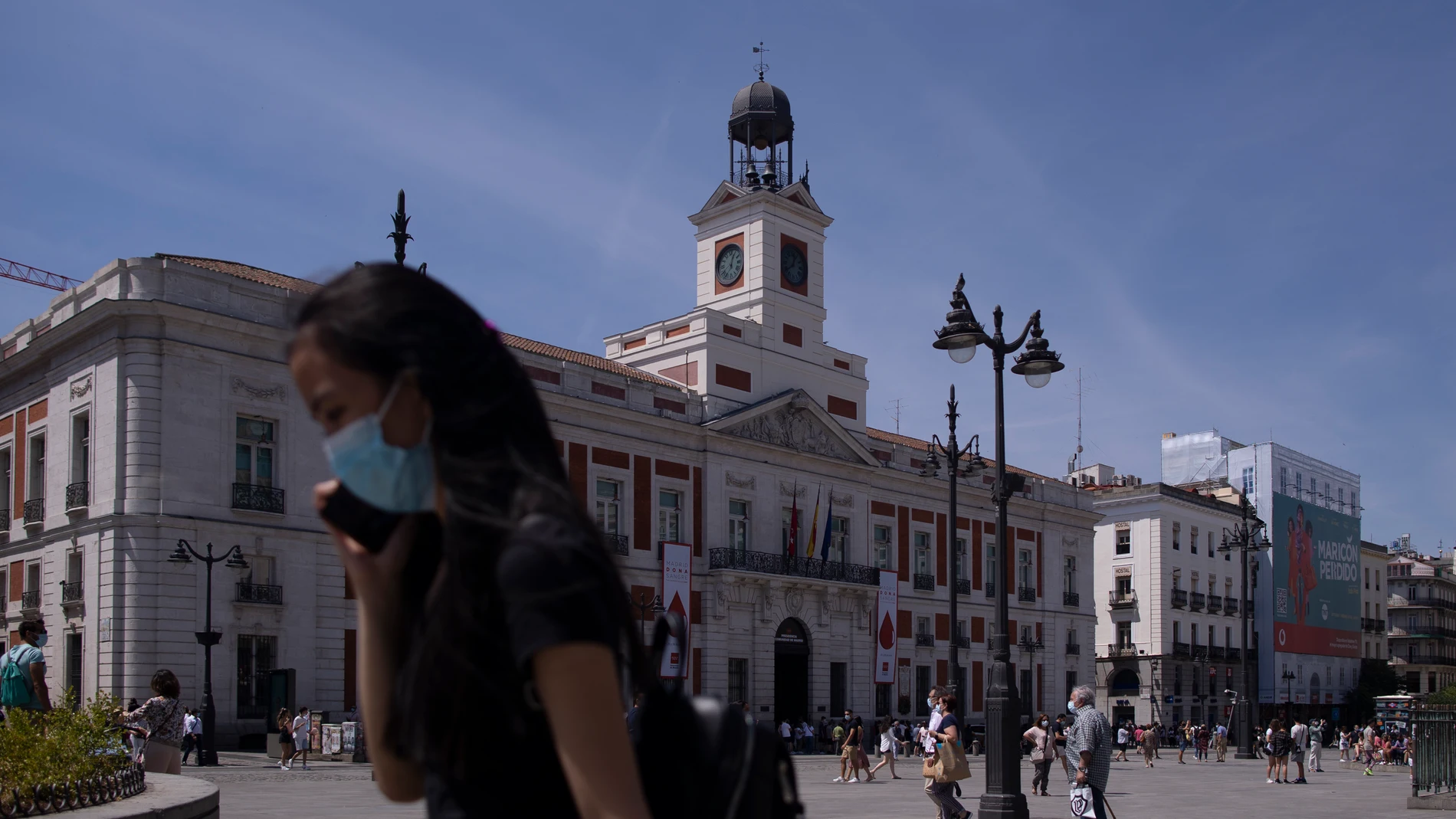 Una mujer con mascarilla en la Puerta del Sol, sede del Gobierno de la Comunidad de Madrid