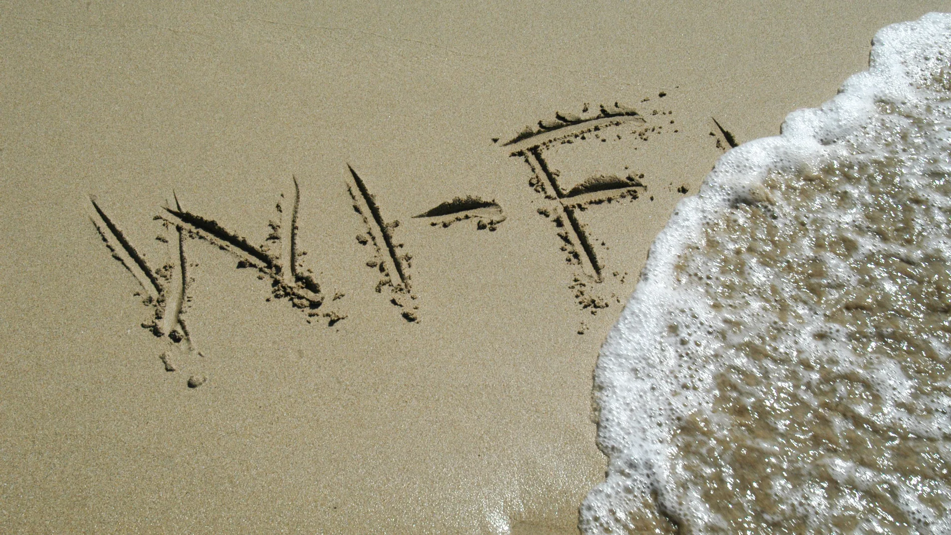 Wi-Fi escrito en la arena que indica Internet sin hilos en la playa.