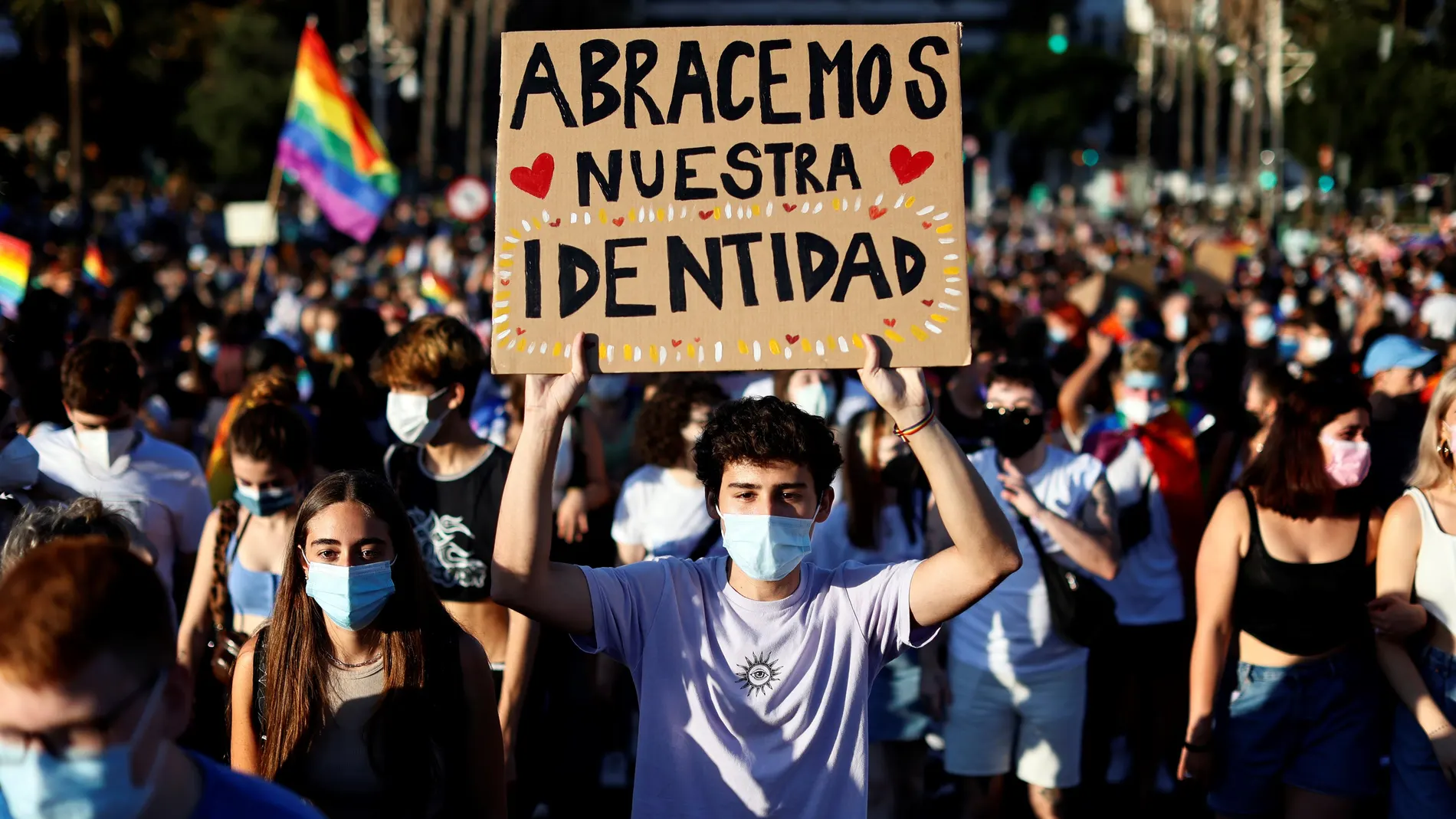 Un joven lleva una pancarta con el lema "Abracemos nuestra identidad" durante la manifestación del Orgullo LGTBIQ+