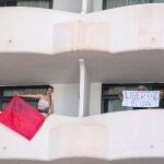 Dos jóvenes que permanecen en aislamiento en el hotel Palma Bellver de Palma portan dos pancartas pidiendo salir del hotel, este martes en Palma de Mallorca