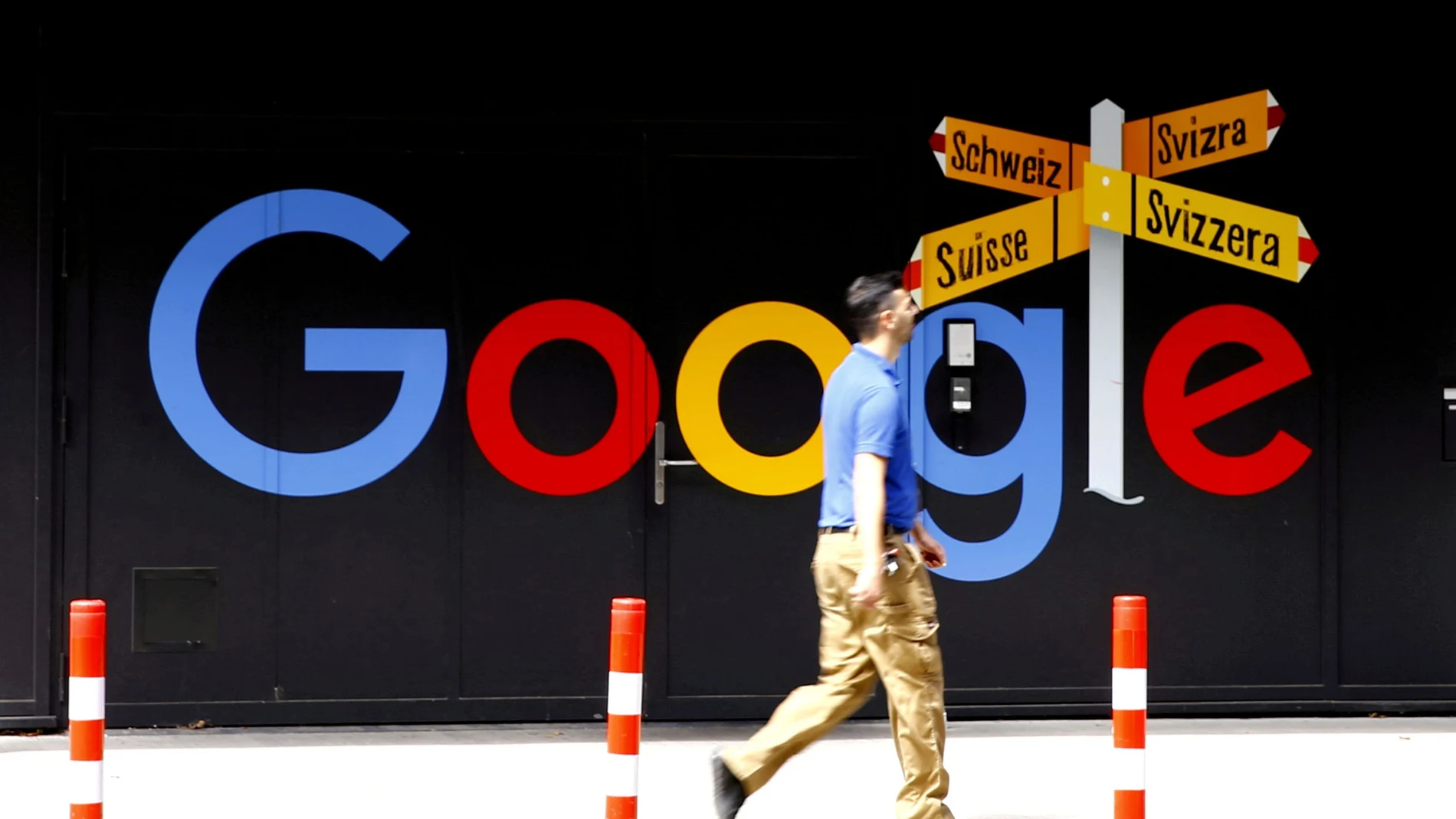 FILE PHOTO: A man walks past a logo of Alphabet Inc's Google in front of at an office building in Zurich, Switzerland July 1, 2020. REUTERS/Arnd Wiegmann/File Photo