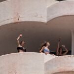 Tres jóvenes que se encuentran en aislamiento tras tener relación directa o indirecta con el brote por covid de un viaje de estudios en Mallorca, bailan en la terraza de una habitación del hotel.