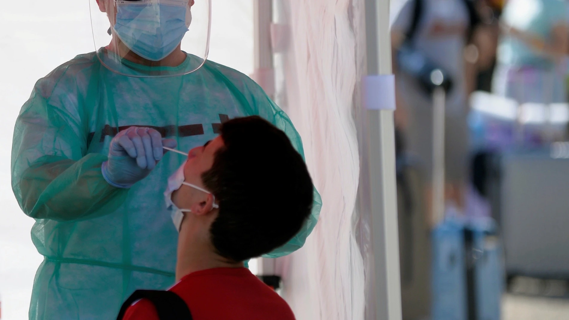 Un efectivo de Cruz Roja realiza una prueba PCR a un joven