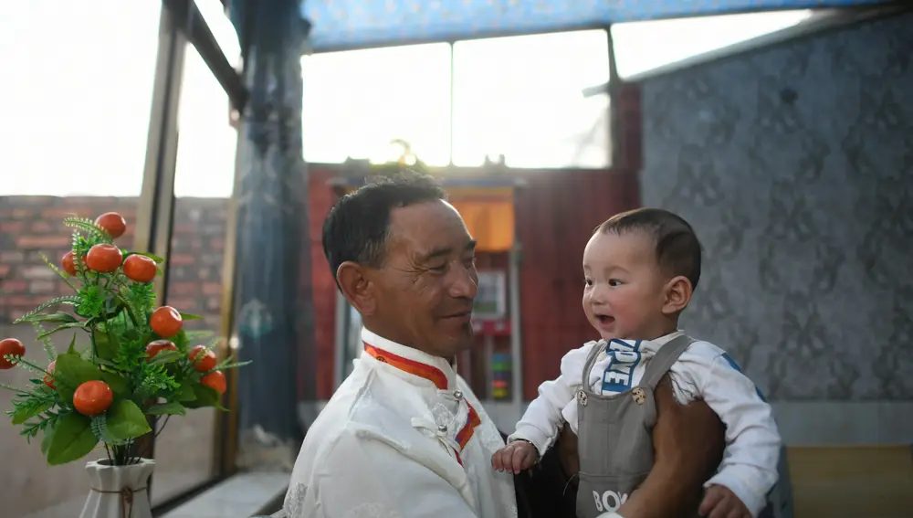 El pastor Sonam Tsering posa para una foto con su nieto en una aldearural montañosa en el distrito de Gangcha de la prefectura autónomatibetana de Haibei, en la provincia noroccidental china de Qinghai, el 8de junio de 2021
