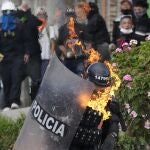 A police officer is engulfed in flames after he was hit with a petrol bomb during an anti-government protest triggered by proposed tax increases on public services, fuel, wages and pensions in Bogota, Colombia, Monday, June 28, 2021. (AP Photo/Fernando Vergara)