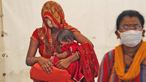 Women wait to receive the vaccine for COVID-19 in New Delhi, India, Friday, July 2, 2021. India crosses a grim mark of 400,000 people lost to the coronavirus, half of them in the past two months during which the virulent delta variant was detected in the country. India, a country of nearly 1.4 billion people, is the third to cross 400,000 deaths, behind the United States and Brazil. (AP Photo/Manish Swarup)