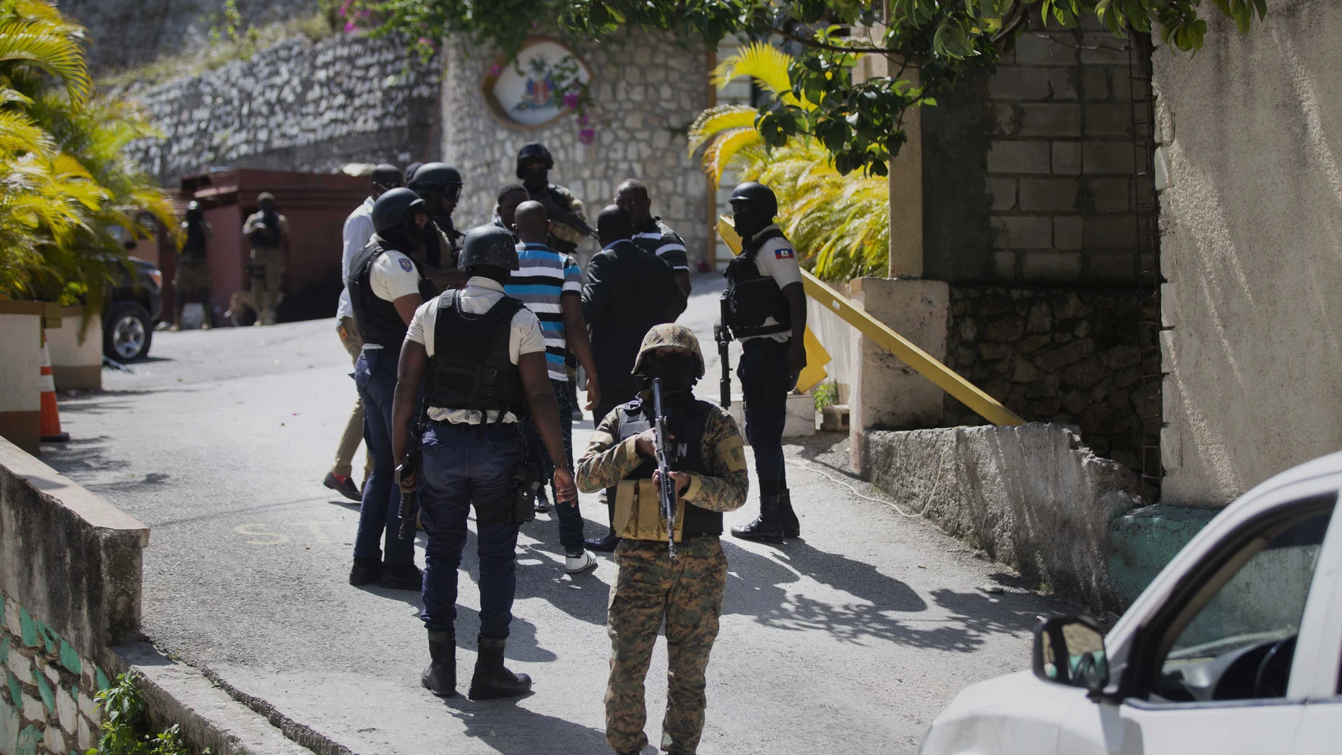Las fuerzas de seguridad realizan una investigación mientras un soldado hace guardia a la entrada de la residencia del presidente haitiano asesinado Jovenel Moise en Puerto Príncipe