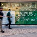 Dos jóvenes se acercan a El Corte Inglés de la calle Arapiles en Madrid este miércoles donde se ha comenzado a vacunar con autocita a la población general de más de 30 años