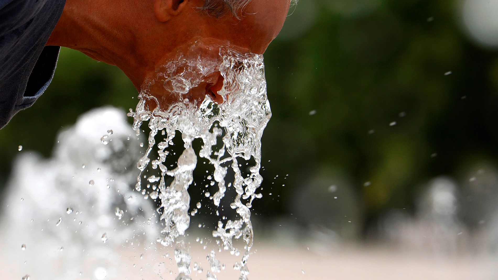 Un hombre se refresca en una de las fuentes de Córdoba para aliviar las altas temperaturas