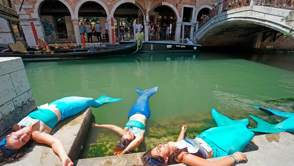 Unas sirenas modernas tumbadas en los canales venecianos como protesta