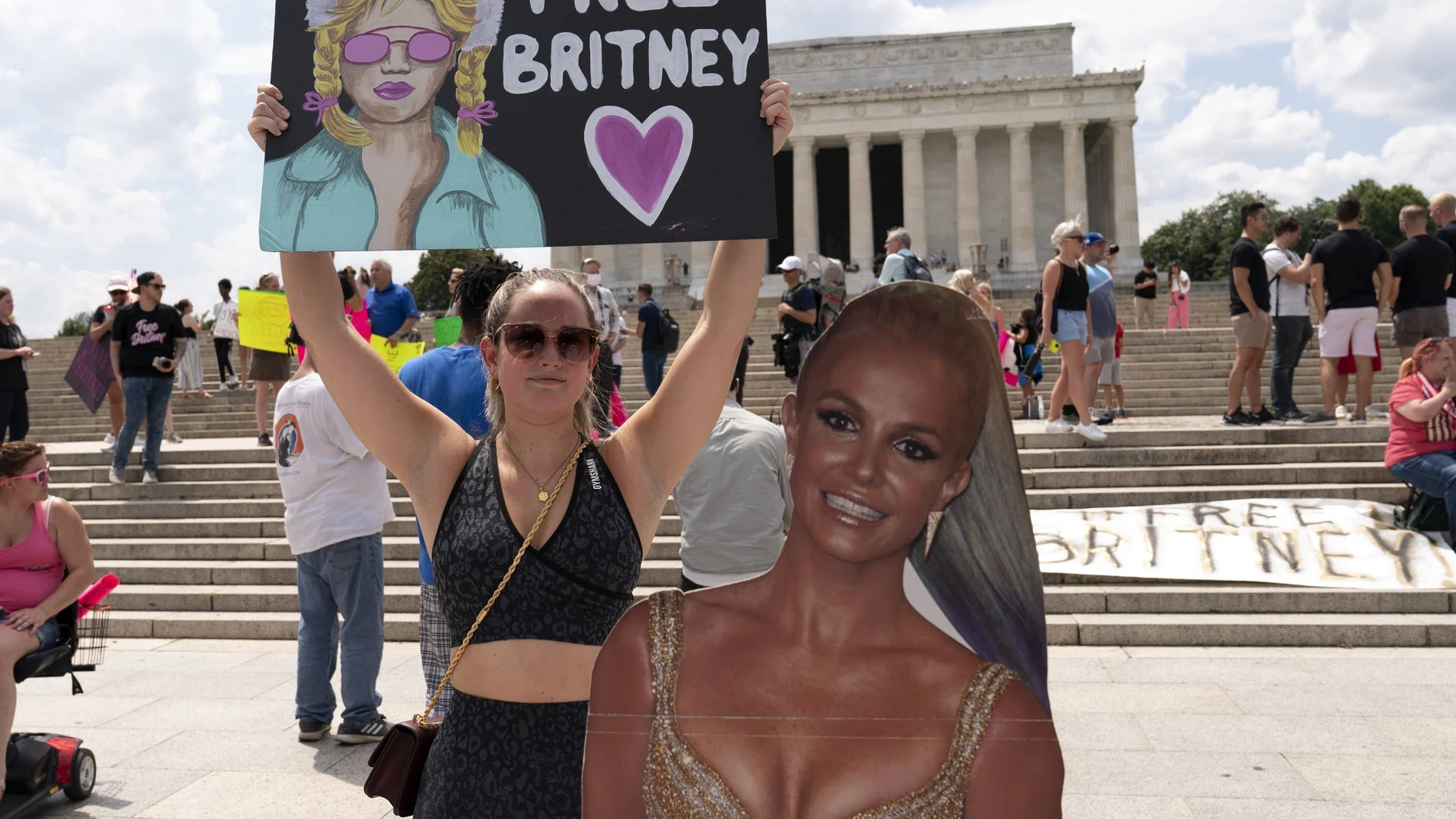 Maggie Howell supporter of pop star Britney Spears protests next to a Britney Spears cardboard cutout at the Lincoln Memorial, during the "Free Britney" rally, Wednesdays, July 14, 2021, in Washington. Rallies have been taking place across the country since the pop star spoke out against her conservatorship in court last month. (AP Photo/Jose Luis Magana)