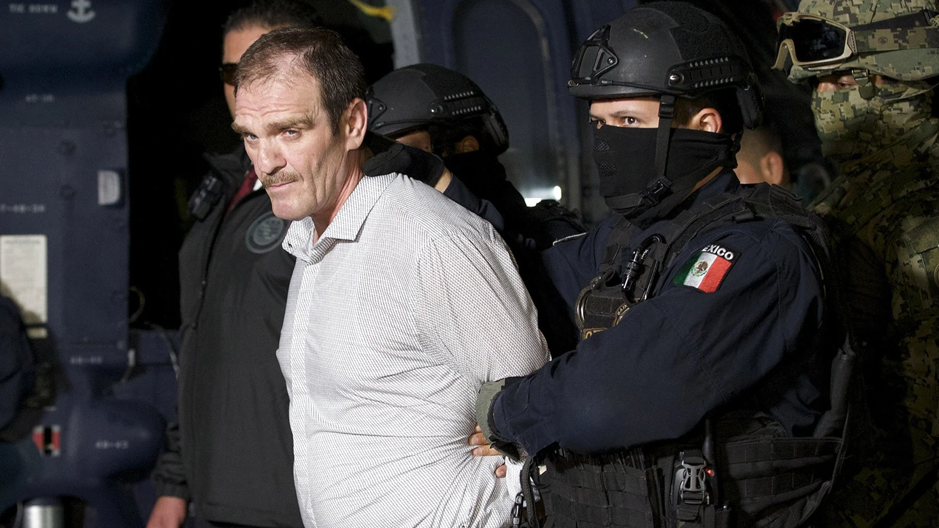 FILE - In this June 15, 2016 file photo provided by the Mexican Attorney General's Office, Hector "El Guero" Palma, is escorted in handcuffs from a helicopter at a federal hanger in Mexico City. An appeals court on Tuesday, July 13, 2021, in Mexico, has overturned PalmaÂ´s acquittal, and was taken to the countryÂ´s maximum security Altiplano prison after the ruling. (Mexico's Attorney General's Office via AP, File)