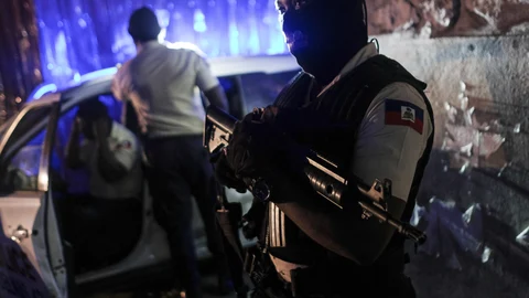 A police officer stands at an intersection in Port-au-Prince, Haiti, late Wednesday, July 14, 2021. Haiti is in the midst of a heightened security situation after the July 7 assassination of President Jovenel Moise. (AP Photo/Matias Delacroix)