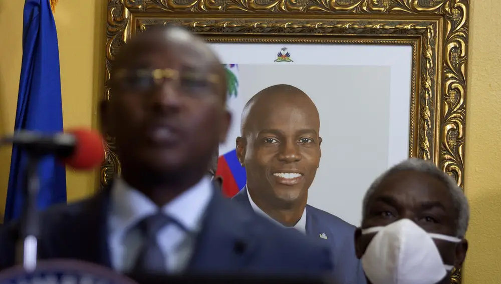 A picture of late Haitian President Jovenel Moise hangs on the wall of his former residence, behind interim Prime Minister Claude Joseph giving a press conference in Port-au-Prince, Tuesday, July 13, 2021. Authorities in Haiti on Thursday forcefully pushed back against reports that current government officials were involved in the July 7 killing of Haitian President Jovenel MoÃ¯se, calling them â€œa lie.â€ (AP Photo/Joseph Odelyn)