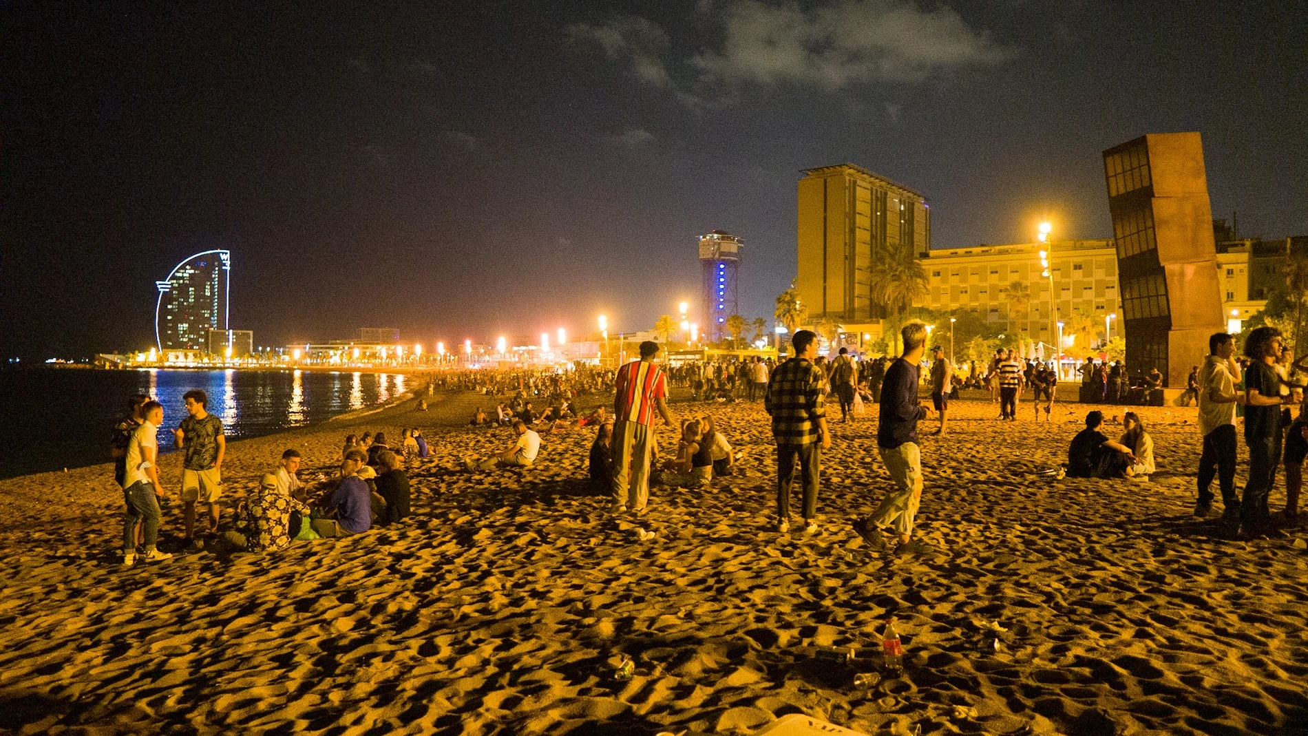 Jóvenes se reúnen en la playa de la Barceloneta horas antes de que entrara en vigor el toque de queda en Cataluña, el 16 de julio