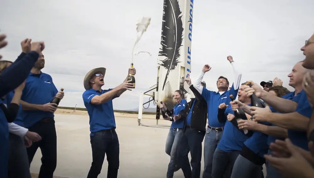 In this undated photo made available by Blue Origin, members of the team celebrate with founder Jeff Bezos at the site of the New Shepard rocket booster landing in West Texas. When Blue Origin launches people into space for the first time, Bezos will be on board. No test pilots or flight engineers for the Tuesday, July 20, 2021 debut flight from West Texas - just Bezos, his brother, an 82-year-old aviation pioneer and a teenager. (Blue Origin via AP)
