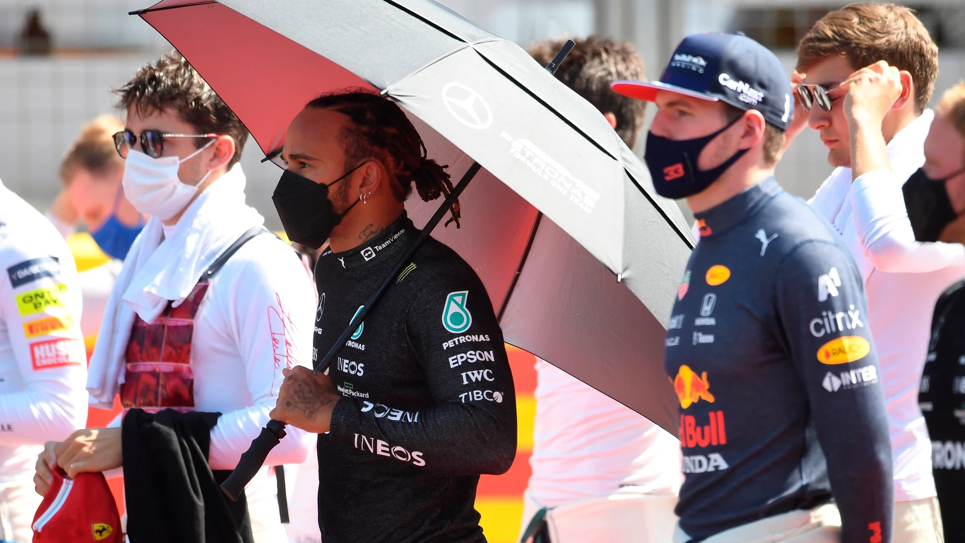 Lewis Hamilton, con paraguas, junto a Max Verstappen.