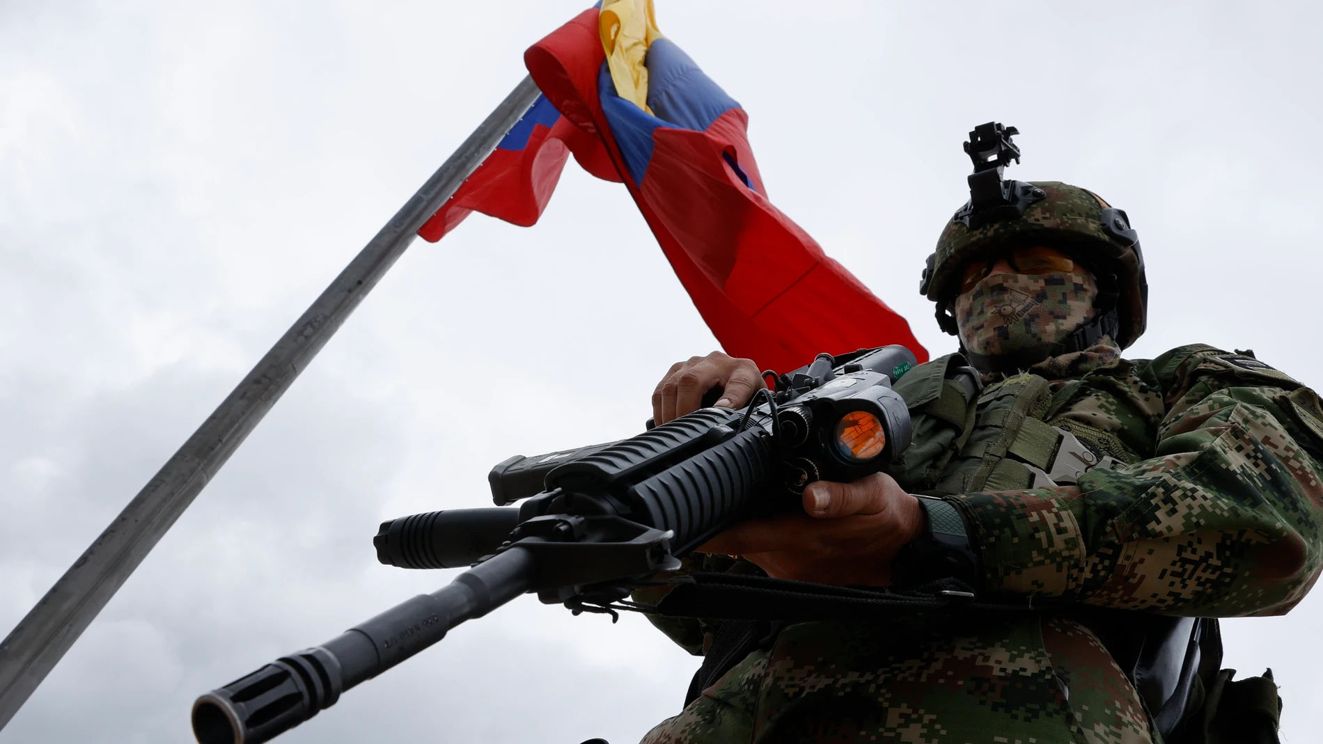 Un soldado presta guardia bajo una bandera colombiana