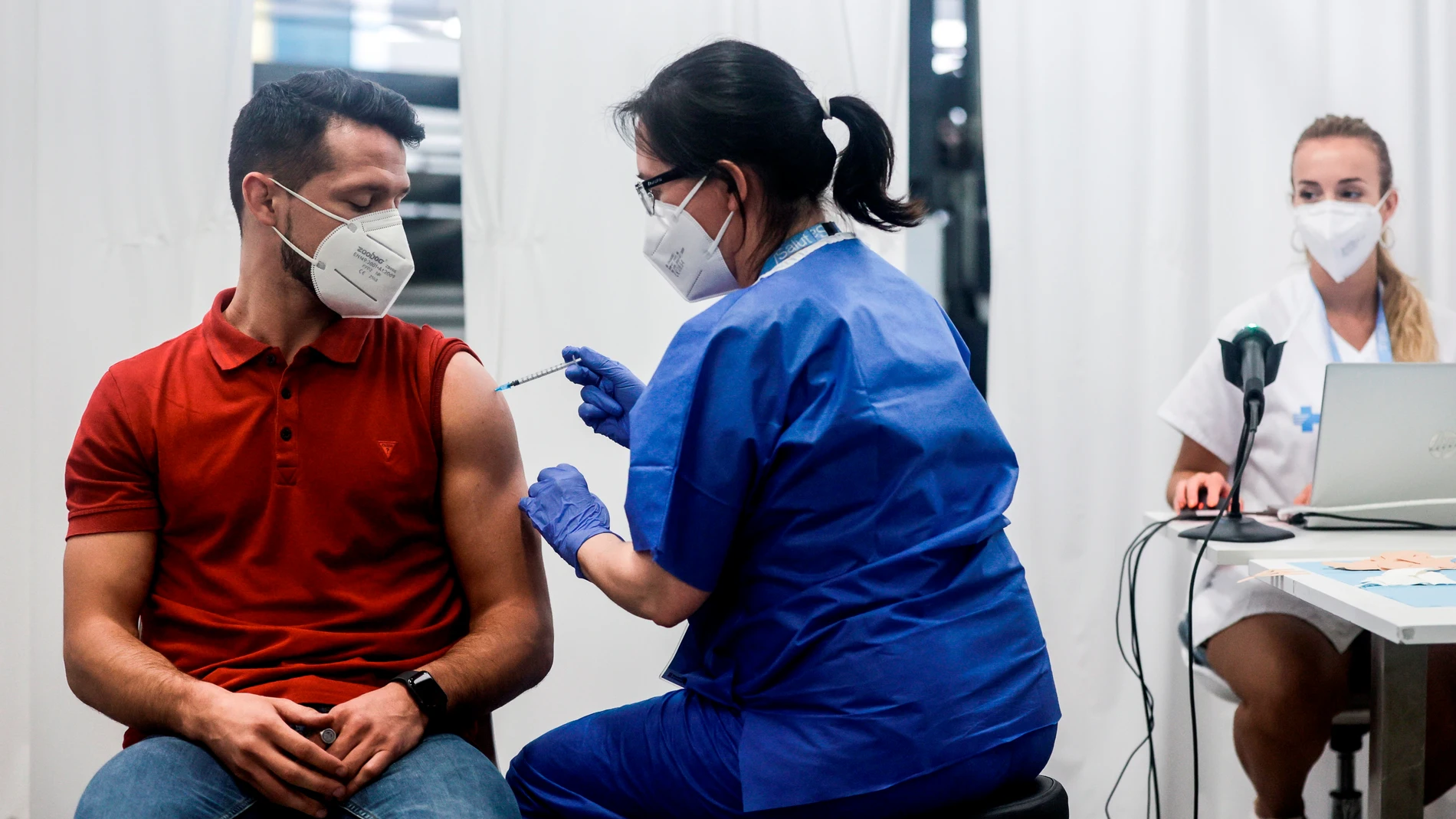El joven de 31 años Oscar Parra, recibió esta tarde de la sanitaria Mercè Costa la vacuna número 500.000 en el centro de vacunación masivo de la Fira de Barcelona. EFE/Quique Garcia