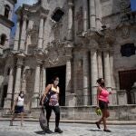 Varias mujeres pasan delante de la Catedral de La Habana, en Cuba