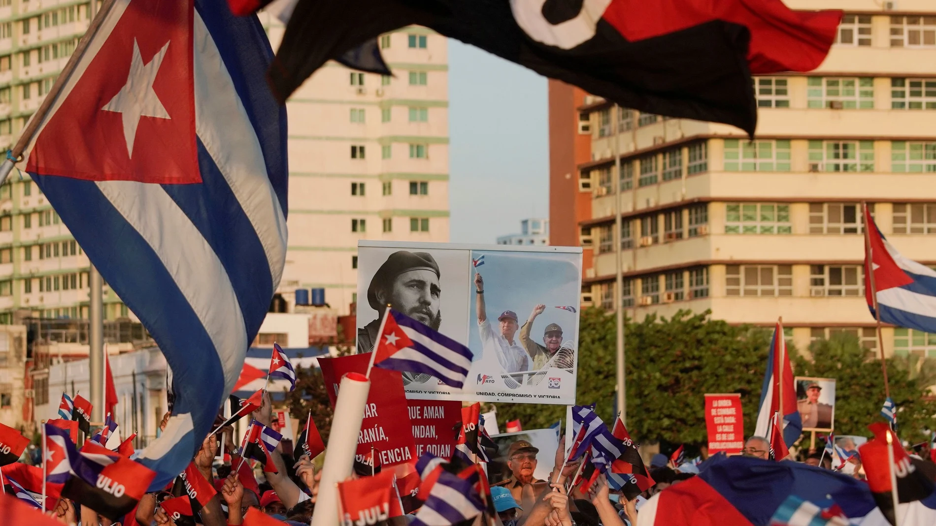 FILE PHOTO: People carry a poster with photographs of Cuba's late President Fidel Castro, Cuba's President and First Secretary of the Communist Party Miguel Diaz-Canel and Cuba's former President and First Secretary of the Communist Party Raul Castro during a rally in Havana, Cuba, July 17, 2021. REUTERS/Alexandre Meneghini/File Photo