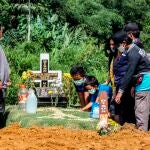 Familiares en un entierro de una víctima de coronavirus en Medan, al norte de Sumatra, Indonesia