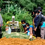 Familiares en un entierro de una víctima de coronavirus en Medan, al norte de Sumatra, Indonesia