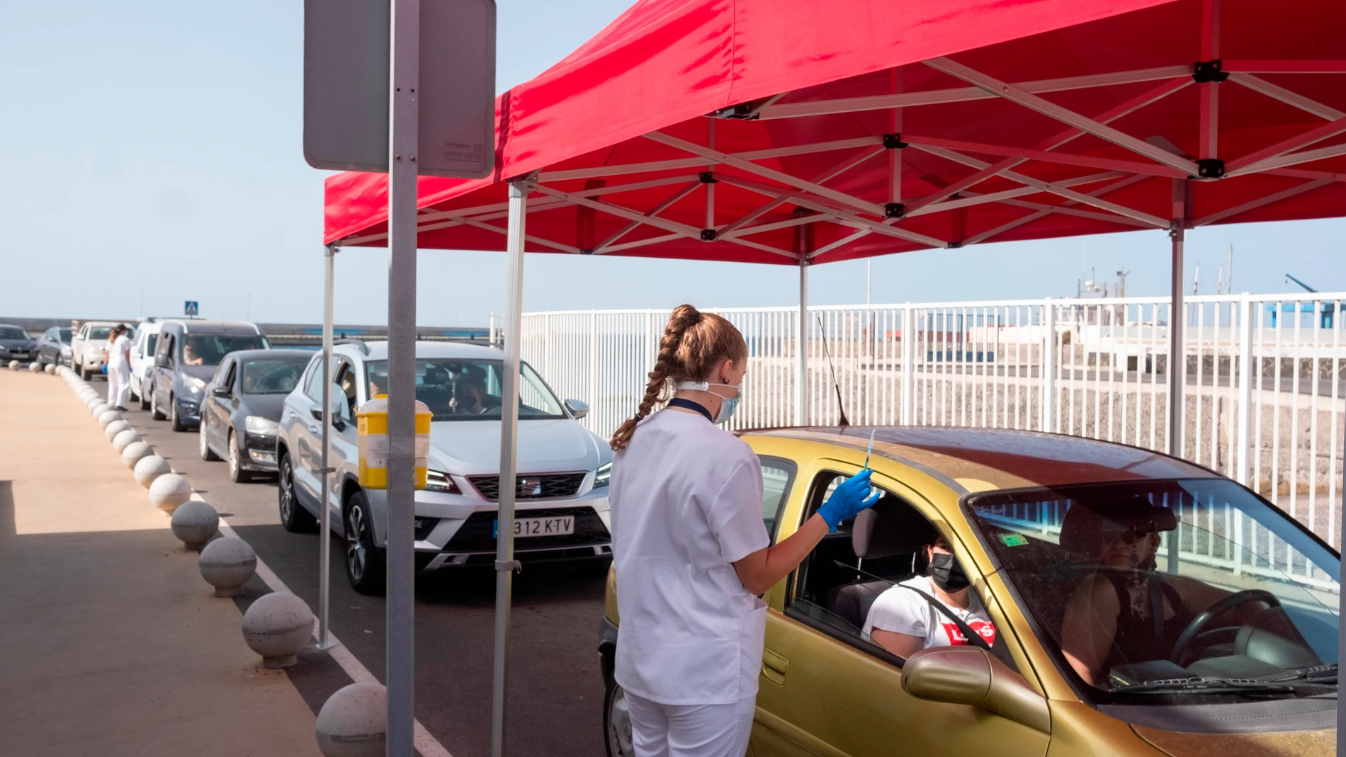 La Consejería de Sanidad del Gobierno de Canarias a comenzado a vacunar contra la covid-19 sin necesidad de cita previa a los jóvenes a partir de 16 años en las islas no capitalinas. En la imagen, una joven recibe su dosis en el centro de vacunación habilitado en el muelle de Gran Tarajal, en Fuerteventura. EFE/Carlos de Saá