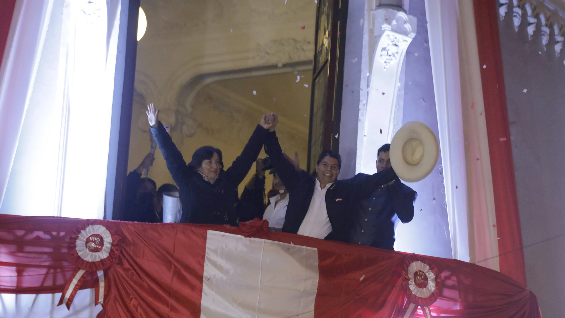 Pedro Castillo, center, celebrates with his running mate Dina Boluarte after being declared president-elect by election authorities at their campaign headquarters in Lima, Peru, Monday, July 19, 2021. Castillo was declared the winner more than a month after elections took place and after opponent Keiko Fujimori claimed that the election was tainted by fraud. (AP Photo/Guadalupe Prado)