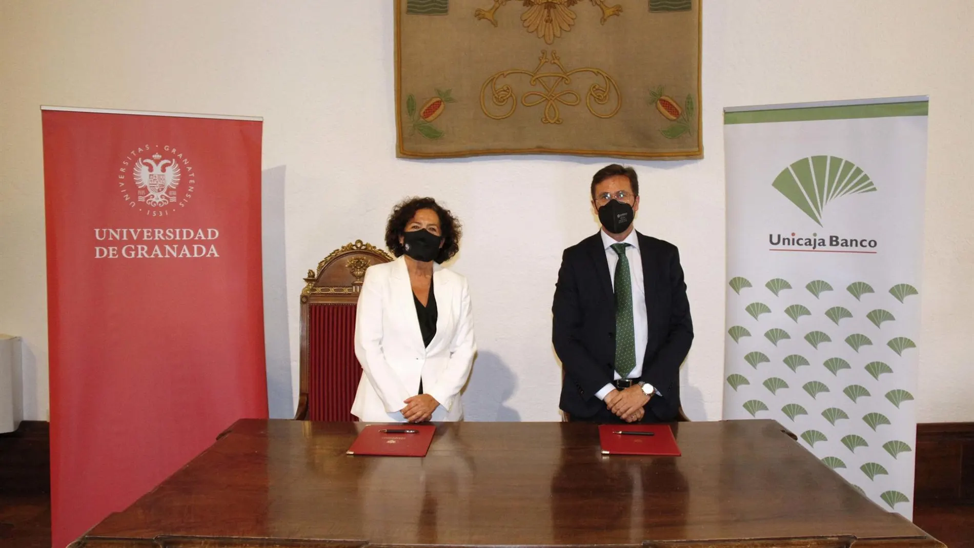 Acto de firma del convenio por el director de área de Granada de Unicaja Banco, Manuel Conde, y la rectora de la Universidad de Granada, Pilar Aranda