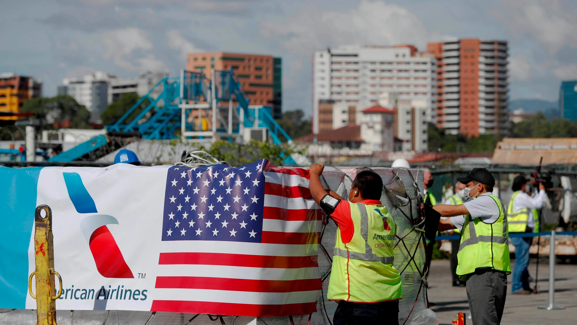 AME3879. CIUDAD DE GUATEMALA (GUATEMALA), 20/07/2021.- Operarios ponen la bandera de Estados Unidos sobre un cargamento de 3 millones dosis de vacunas contra la covid-19 donadas por Estados Unidos a Guatemala, hoy, en el Aeropuerto Internacional La Aurora, en Ciudad de Guatemala (Guatemala). Estados Unidos despachó este martes 3 millones de vacunas contra la covid-19 a Guatemala, como parte de la estrategia del Gobierno del presidente de EE.UU., Joe Biden, de convertise en un proveedor de dosis gratuitas a los distintos países. EFE/ Esteban Biba