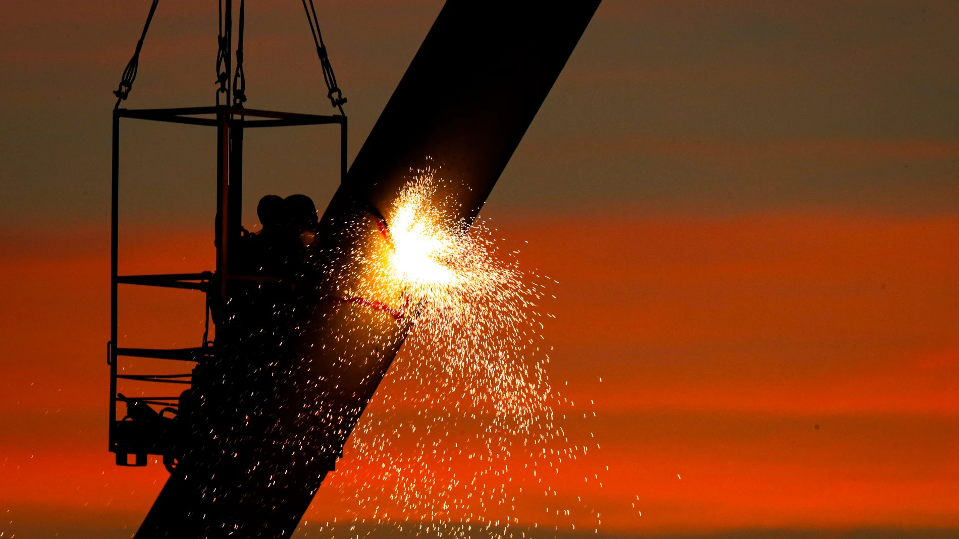 Trabajadores realizan obras de remodelación de grúas en un puerto