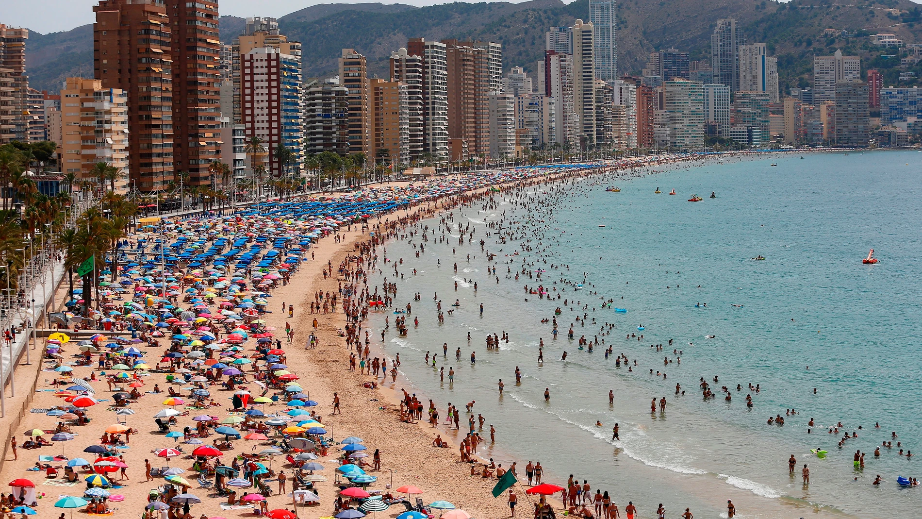 Cientos de turistas disfrutan de la playa de Levante de Benidorm, en Alicante